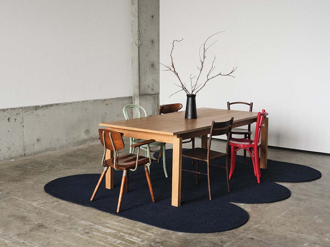 Dining area with custom curvy navy wool rug 